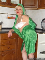 Mature housewife undressing in the kitchen