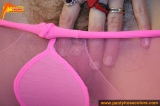 Pink pantyhose blonde girl caressing her nylons on the bed