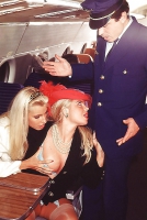 Two blondes servicing the captain on an airplane